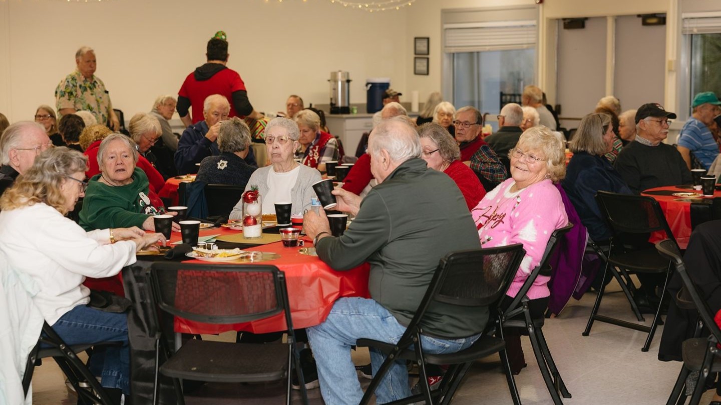 Seniors at the annual Holiday Lunch at the Riverfront Community Center eat and fill out a survey for the strategic planning process.